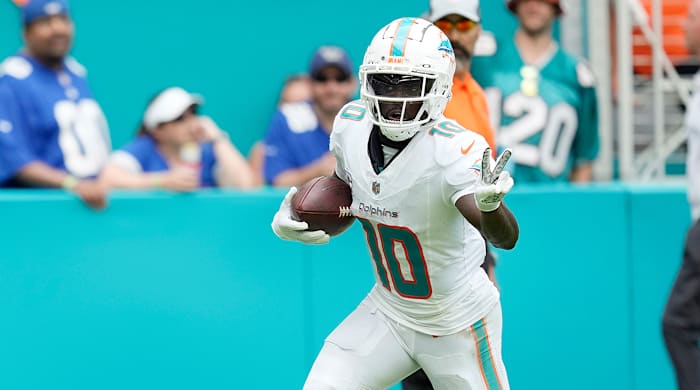 Dolphins wide receiver Tyreek Hill (10) gestures as he runs for a touchdown.